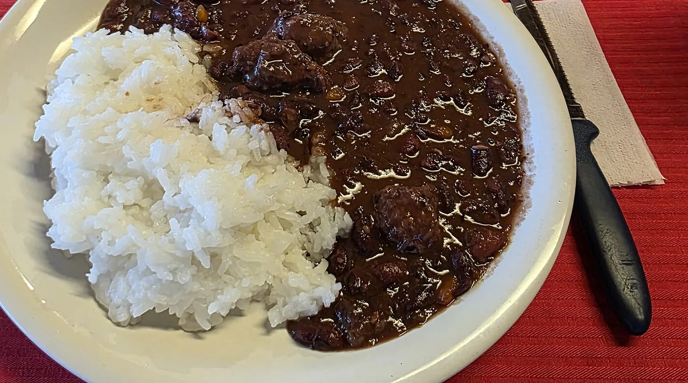 Plato de arroz blanco con frijol oscuro