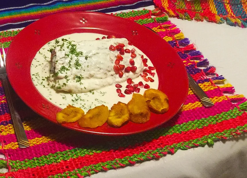 Plato rojo con salsa blanca y plátano frito