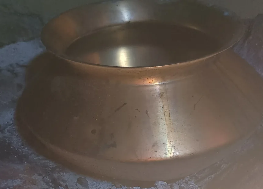 Olla de metal sobre piedras de un fogón